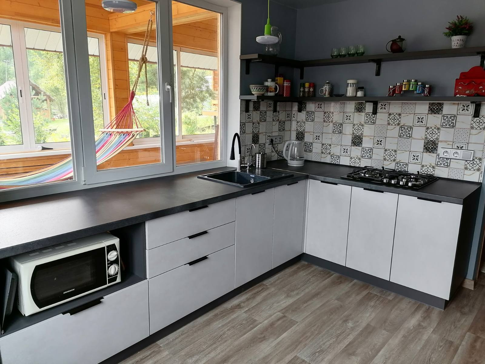 Современная угловая кухня без верхних навесных шкафов в загородный дом - фото - 6