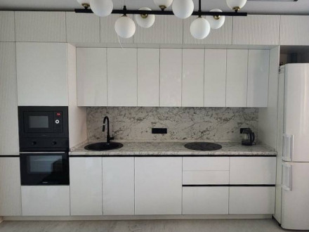 Белая современная кухня под потолок с рифлеными антресольными шкафами - фото - 1