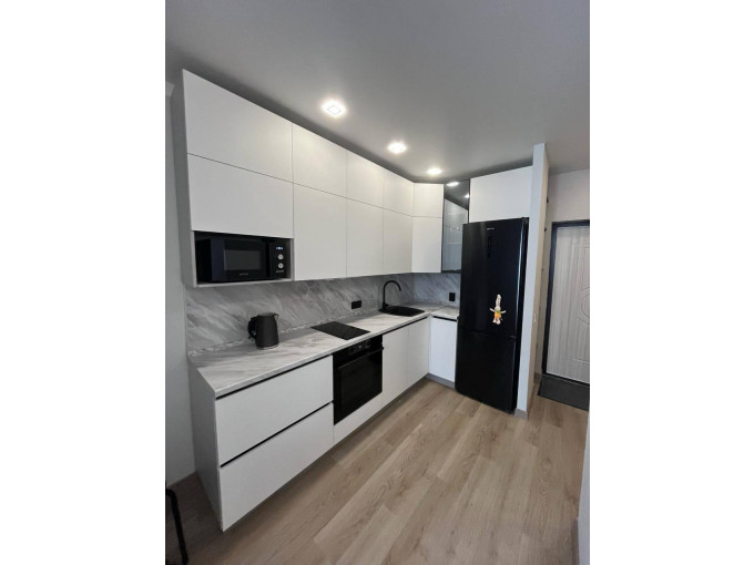 Белая угловая кухня с минималистичными фасадами без ручек - фото - 1